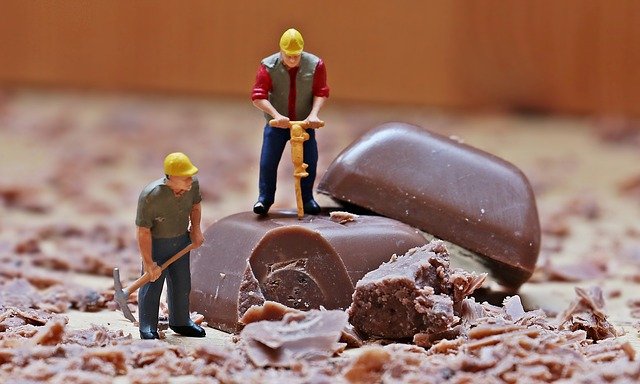 2 miniature figurs mining a cholate bar